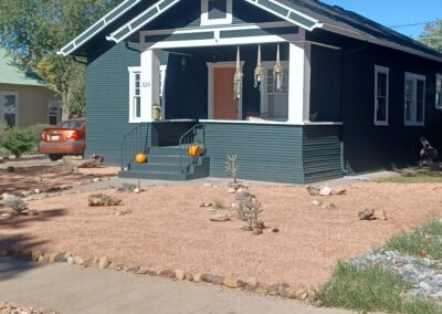 A house with green siding and a black roof.